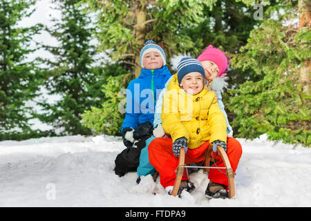 Group of kids slide down on sledge in the park Stock Photo