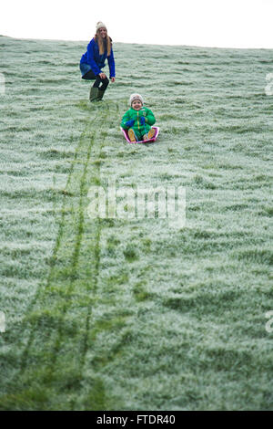 Sledging on frosty grass without proper snow Stock Photo