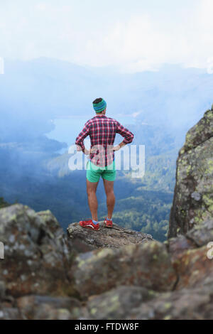 Caucasian man enjoying the view after a mountain hike Stock Photo