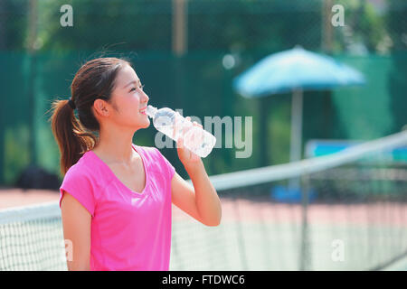 Young Japanese tennis player on the court Stock Photo