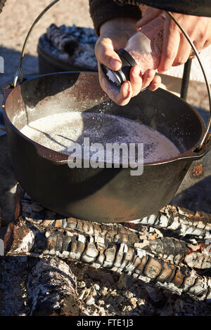 cook grinding pepper into a cast iron pot, traditional cowboy style cooking, farmer's market, Alpine, Texas, USA Stock Photo