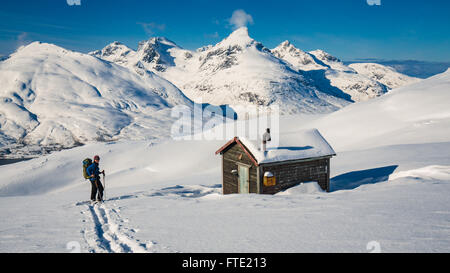 Ski touring to cabin on Rodtinden with views towards Store Blamann and the open ocean, Kvaloya Troms, Northern Norway Stock Photo