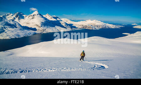 Skiing on Rodtinden with views towards Store Blamann and the open ocean, Kvaloya Troms, Northern Norway Stock Photo