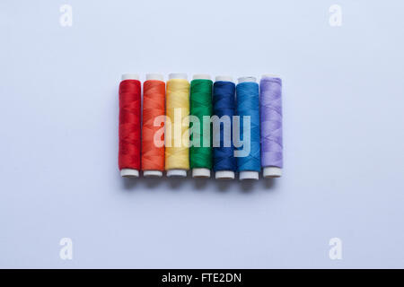 Colourful thread in the colours of the rainbow arranged on a white background Stock Photo