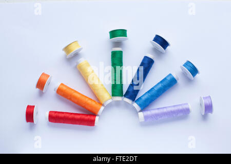 Colourful thread in the colours of the rainbow arranged on a white background Stock Photo