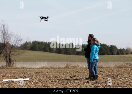 Two people flying a drone over a field. Stock Photo