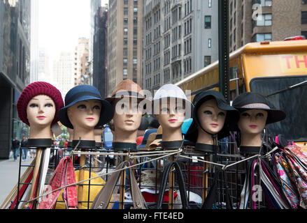 Six mannequin dummy heads wearing hats displayed on frame outside in Times Square, New York. Stock Photo