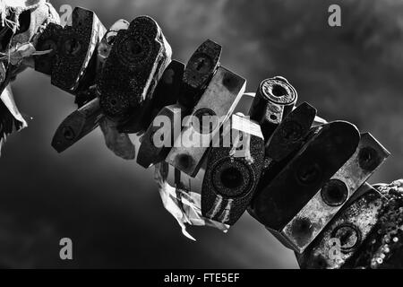 Line of old rusting metal padlocks locked and secured. White background sky area with copy space for love as eternity, and symbo Stock Photo