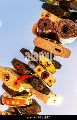 Line of various old rusting metal padlocks in different shapes locked and secured. Blue clear background sky area with copy spac Stock Photo