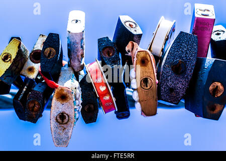 Line of various old rusting metal padlocks in different shapes locked and secured. Blue clear background sky area with copy spac Stock Photo