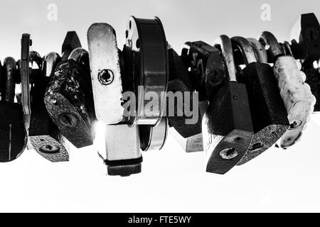 Line of old rusting metal padlocks locked and secured. White background sky area with copy space for love as eternity, and symbo Stock Photo