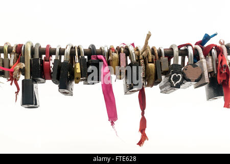 Line of various old rusting metal padlocks in different shapes locked and secured. White background sky area with copy space for Stock Photo