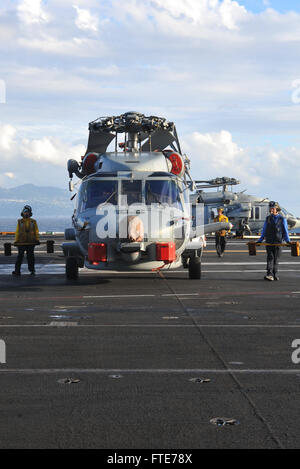 TYRRHENIAN SEA (Nov. 4, 2013) Sailors move an MH-60R Seahawk helicopter assigned to the “Wolf Pack” of Helicopter Maritime Strike Squadron (HSM) 75 on the flight deck of the aircraft carrier USS Nimitz (CVN 68). Nimitz is deployed supporting maritime security operations and theater security cooperation efforts in the U.S. 6th Fleet area of operations. (U.S. Navy photo by Mass Communication Specialist Seaman Eric M. Butler/ Released) Stock Photo