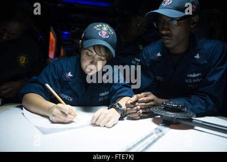 Aksaz, Turkey (Nov. 12, 2013) - Operations Specialist 2nd Class Samantha Domenech, left, and Operations Specialist 2nd Class Paul Harris decipher incoming command codes in the combat information center aboard the Arleigh Burke-class guided-missile destroyer USS Stout (DDG 55) while departing Aksaz Naval Base to support Exercise Dogu Akdeniz 2013. The exercise was hosted by Commander, Turkish Fleet to support interoperability efforts. Stout, homeported in Norfolk, Va., is on a scheduled deployment supporting maritime security operations and theater security cooperation efforts in the U.S. 6th F Stock Photo