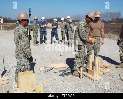 140326-N-ZZ999-040 DEVESELU AIR BASE, Romania (March 26, 2014) - Construction Electrician 3rd Class Julito Dacpano and Engineering Aide Constructionman Deshay Baskin, attached to Naval Mobile Construction Battalion 74 Detail Romania, survey a job site for an upcoming project. (U.S. Navy photo by Utilitiesman Constructionman  Sydney Thorne)  Join the conversation on Twitter ( https://twitter.com/naveur navaf )  follow us on Facebook ( https://www.facebook.com/USNavalForcesEuropeAfrica )  and while you're at it check us out on Google+ ( https://plus.google.com/101085806745039159791/posts#1010858 Stock Photo