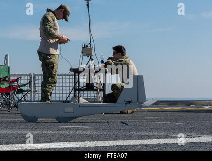 140217-N-ZY039-016 AT SEA (Feb. 17, 2014) - Fire Controlman 2nd Class Dustin Gower, left, and Hull Maintenance Technician 2nd Class Paul Hobson, Sailors assigned to the PUMA unmanned aerial vehicle (UAV) detachment aboard joint, high-speed vessel USNS Spearhead (JHSV 1), set up the control systems for a UAV. Spearhead, the U.S. Navy's first-in-class joint, high-speed vessel, is on its maiden deployment supporting theater security cooperation efforts in the U.S. 6th Fleet area of operations. (U.S. Navy photo by Mass Communication Specialist Seaman Justin R. DiNiro/ Released)  Join the conversat Stock Photo