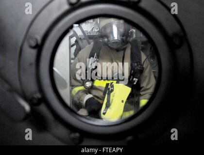 140303-N-CH661-523 MEDITERRANEAN SEA (March 3, 2014) - Gas Turbine Systems (Mechanical) Fireman Gerard Plowden, aboard the guided-missile destroyer USS Ramage (DDG 61), enters a hatch to the main engine room during a firefighting exercise. Ramage, homeported in Norfolk, Va., is on a scheduled deployment supporting maritime security operations and theater security cooperation efforts in the U.S. 6th Fleet area of operations. (U.S. Navy photo by Mass Communication Specialist 2nd Class Jared King/Released)  Join the conversation on Twitter ( https://twitter.com/naveur navaf )  follow us on Facebo Stock Photo