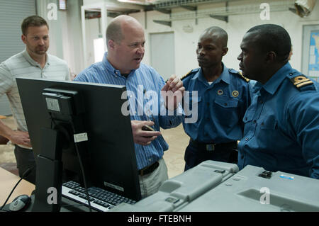This image captures Gary Shaffer, an exercise science advisor, explaining satellite tracking to Sierra Leone Navy officers during Exercise Saharan Express 2014 in Dakar, Senegal. The exercise focuses on improving maritime safety and security in West Africa. Stock Photo