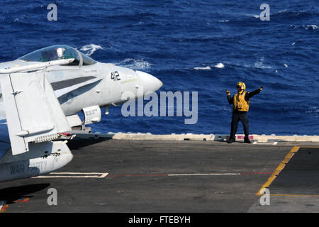 140315-N-CZ979-001 MEDITERRANEAN SEA (March 15, 2014) A sailor directs an F/A-18C Hornet attached to the “Golden Warriors” of Strike Fighter Squadron (VFA) 87 as it taxis on the flight deck of the aircraft carrier USS George H.W. Bush (CVN 77). George H. W. Bush is on a scheduled deployment supporting maritime security operations and theater security cooperation efforts in the U.S. 6th Fleet area of operations.  (U.S. Navy photo by Mass Communication Specialist 3rd Class Joshua Card/Released) Stock Photo