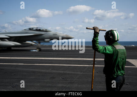 140315-N-SI489-224  MEDITERRANEAN SEA (March 15, 2014) Aviation Boatswain’s Mate (Equipment) Airman Justin Fortin, from Titusville, Fla., waits to recover the arresting cable while an F/A-18F Super Hornet, attached to the “Fighting Black Lions” of Strike Fighter Squadron (VFA) 213, prepares to land on the flight deck aboard the aircraft carrier USS George H.W. Bush (CVN 77). George H. W. Bush is on a scheduled deployment supporting maritime security operations and theater security cooperation efforts in the U.S. 6th Fleet area of operations. (U.S. Navy photo by Mass Communication Specialist Se Stock Photo