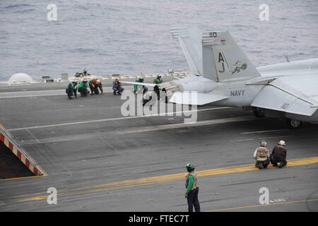 140316-N-SI489-033  MEDITERRANEAN SEA (March 16, 2014) Sailors brace themselves as an F/A-18E Super Hornet, attached to the “Tommcatters” of Strike Fighter Squadron (VFA) 31, prepares to take off from the flight deck of the aircraft carrier USS George H.W. Bush (CVN 77). George H. W. Bush is on a scheduled deployment supporting maritime security operations and theater security cooperation efforts in the U.S. 6th Fleet area of operations. (U.S. Navy photo by Mass Communication Specialist Seaman Andrew Johnson/Released) Stock Photo