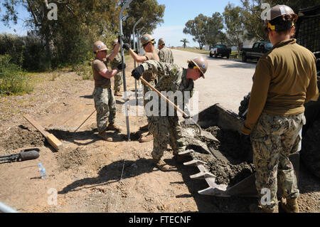 140325-N-YB423-005 ROTA, Spain (March 25, 2014) - Builder Constructionman Alexis Franklin (center), attached to Naval Mobile Construction Battalion 74 Detail Rota, shovels concrete alongside other Seabees as part of the Flight Line fence repair project. (U.S. Navy photo by Mass Communication Specialist 2nd Class Ryan Williams)  Join the conversation on Twitter ( https://twitter.com/naveur navaf )  follow us on Facebook ( https://www.facebook.com/USNavalForcesEuropeAfrica )  and while you're at it check us out on Google+ ( https://plus.google.com/101085806745039159791/posts#10108580674503915979 Stock Photo