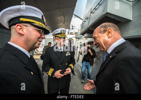 140414-N-KE519-070 CONSTANTA, Romania (April 14, 2014) - Romanian President Traian Băsescu (right) speaks with Cmdr. Scott Jones, commanding officer of the forward-deployed Arleigh Burke-class guided-missile destroyer USS Donald Cook (DDG 75) (left) and Cmdr. Charles Hampton, Donald Cook's executive officer, during his visit to the ship. Donald Cook, the first of four Arleigh Burke-class destroyers to be forward-deployed to Rota, Spain, is serving on a scheduled patrol in the U.S. 6th Fleet area of operations as part of the President's European Phased Adaptive Approach (EPAA) to ballistic miss Stock Photo