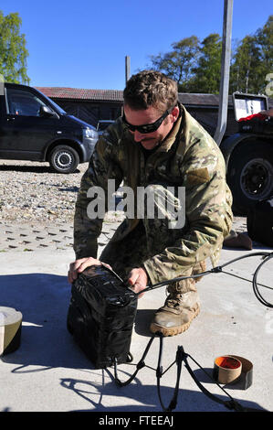140516-N-QY759-039 PAVILOSTA, Latvia (May 16, 2014) - Explosive Ordnance Disposal Technician 2nd Class Matthew Lewis assigned to Explosive Ordnance Disposal Mobile Unit 8 (EODMU),  prepares an explosive charge to be used in the safe detonation of a World War II German mine recovered from the wreck of a minelayer. EODMU 8 participated in Open Spirit, a multinational operation that disposes of mines and other ordnance remaining on the seabed from World War I and World War II to reduce the risk to navigation, fishing and to the environment in the Baltic Sea. (U.S. Navy photo by Mass Communication Stock Photo