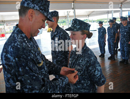 140725-N-VY489-011  GAETA, Italy (July 25, 2014) – Adm. Mark Ferguson, commander, U.S. Naval Forces Europe-Africa, pins an Enlisted Surface Warfare Specialist qualification on Electronics Technician 3rd Class Rachel Stewart before an all hands call with Sailors aboard the U.S. 6th Fleet command and control ship USS Mount Whitney (LCC 20). Mount Whitney, homeported in Gaeta, Italy, operates with a combined crew of U.S. Sailors and Military Sealift Command (MSC) civil service mariners. (U.S. Navy Photo by Mass Communication Specialist 2nd Class Mike Wright/Released) Stock Photo