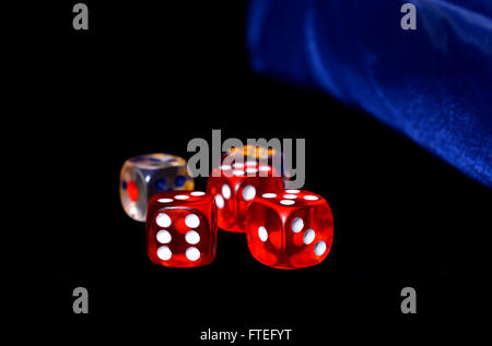 Red and Silver transparent dice on a black felt. Stock Photo