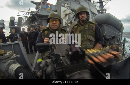 140924-N-RB546-282 ATLANTIC OCEAN (Sep. 24, 2014) Gunner’s Mate 3rd Class Chris Valentine shoots a .50 caliber machine gun as Gunner’s Mate Chief Petty Officer Michael Spofford administers the crew served weapons qualification on USS Mitscher (DDG 57). The Arleigh Burke-class, guided-missile destroyer is on deployment scheduled to conduct Maritime Security Operations and Ballistic Missile Defense in the U.S. 5th and 6th Fleet area of responsibility. (U.S. Navy photo by Mass Communication Specialist 2nd Class Anthony R. Martinez/Released) Stock Photo