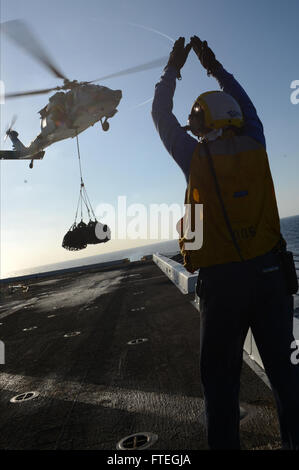 MEDITERRANEAN SEA (Oct. 3, 2014) -- Aviation Boatswain's Mate (Handling) 3rd Class Kimberly Toro, from Galveston, Texas, signals an UH-1 Huey aboard the flight deck of the amphibious transport dock ship USS Mesa Verde (LPD 19) during a vertical replenishment-at-sea with Military Sealift Command fleet replenishment oiler USNS Leroy Grumman (T-AO 195). Mesa Verde, part of the Bataan Amphibious Ready Group with the embarked 22nd Marine Expeditionary Unit, is conducting naval operations in the U.S. 6th Fleet area of operations in support of U.S. national security interests in Eu Stock Photo