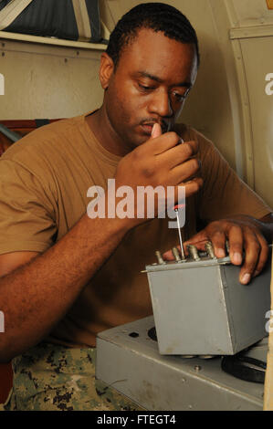 Aviation Electronics Technician 2nd Class Jamal Napier performs maintenance on flight-station control switches aboard the P-3C Orion aircraft, part of Patrol Squadron FOUR. The operation supports U.S. naval operations in the 6th Fleet area, ensuring mission readiness and national security. Stock Photo