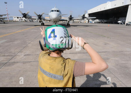 SIGONELLA, Sicily (Oct. 10, 2014) - Aviation Structural Mechanic 2nd Class Margaret Mele signals a P-3C Orion maritime patrol aircraft attached to Patrol Squadron FOUR (VP-4). VP-4 is conducting naval operations in the U.S. 6th Fleet area of operations in support of U.S. national security interests in Europe. Stock Photo