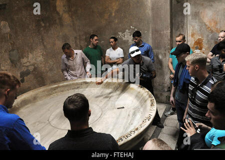 NAPLES, Italy (Oct. 13, 2014) - Sailors and Marines observe an ancient sauna room during a tour of Pompeii while to a liberty port visit in Naples, Italy. Bataan, homeported in Norfolk, Va., is conducting naval operations in the U.S. 6th Fleet area of operations in support of U.S. national security interests in Europe. Stock Photo