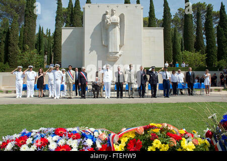 : DRAGUIGNAN, France (August 16, 2013) – Visitors and distinguished guest render honors as the national anthem of the U.S. and France are played during a ceremony at the Rhone American Cemetery in honor of the 69th anniversary celebration of allied troops landing in Provence during World War II. This visit serves to continue U.S. 6th Fleet efforts to build global maritime partnerships with European nations and improve maritime safety and security. Stock Photo