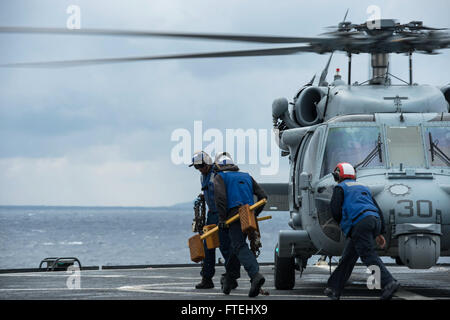 MEDITERRANEAN SEA (Oct. 29, 2014) – Flight deck crew prepare an MH-60S Sea Hawk helicopter assigned to the Ghostriders of Helicopter Sea Combat Squadron (HSC 28), Detachment 1, aboard the U.S. 6th fleet command and control ship USS Whitney (LCC 20) for lift off. Mount Whitney is conducting naval operations with allies and partners in the U.S. 6th Fleet area of operations in order to advance security and stability in Europe. Stock Photo