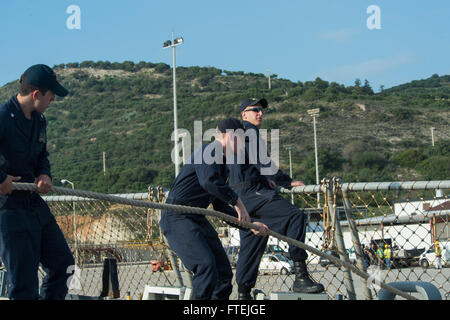 SOUDA BAY, Greece (Dec. 4, 2014) Sailors heave in mooring lines aboard USS Cole (DDG 67) as the ship departs Souda Bay following a scheduled port visit, Dec. 4, 2014. Cole, an Arleigh Burke-class guided-missile destroyer, homeported in Norfolk, is conducting naval operations in the U.S. 6th Fleet area of operations in support of U.S. national security interests in Europe. Stock Photo