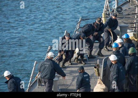 AUGUSTA BAY (Dec. 8, 2014) Sailors aboard USS Cole (DDG 67) heave in mooring lines as the ship pulls in to Augusta Bay, Sicily, during a scheduled port visit Dec. 8, 2014. Cole, an Arleigh Burke-class guided-missile destroyer, homeported in Norfolk, is conducting naval operations in the U.S. 6th Fleet area of operations in support of U.S. national security interests in Europe. Stock Photo