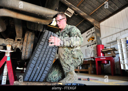 150128-N-OR477-128 NAVAL STATION ROTA, Spain (Jan 28, 2015) Construction Mechanic Constructionman Joshua Jamison, assigned to Naval Mobile Construction Battalion (NMCB) 11, removes a tire form a duty truck Jan. 28, 2015.  NMCB 11, homeported out of Gulfport, Mississippi, is currently deployed at Rota. (U.S. Navy photo by Mass Communication Specialist 1st Class Michael C. Barton/ Released) Stock Photo
