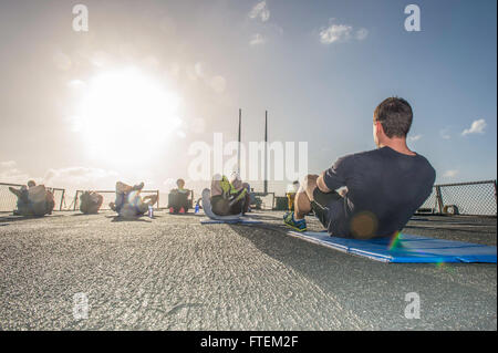 ATLANTIC OCEAN (Feb. 19, 2015) Ensign Joseph Lillie, USS Laboon (DDG 58) first lieutenant, performs sit-ups while leading Sailors in command physical training aboard ship Feb. 19, 2015. Laboon, an Arleigh Burke-class guided-missile destroyer home ported in Norfolk, is underway conducting naval operations in the U.S. 6th Fleet area of operations in support of U.S. national security interests in Europe. Stock Photo