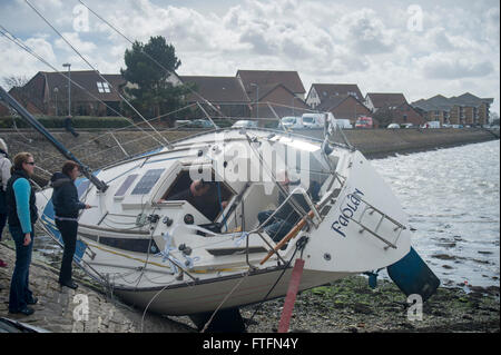 Portsmouth Harbour, Hampshire, UK. 28th March, 2016. The yacht, 'Faolan' lies almost on her side on the shore after being swept from her anchorgae during Storm Katie on Easter Monday. Credit:  Rob Wilkinson/Alamy Live News Stock Photo