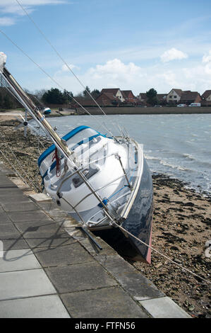 Portsmouth Harbour, Hampshire, UK. 28th March, 2016.  Yacht washed up against the sea wall after being swept from her anchorgae during Storm Katie on Easter Monday. Credit:  Rob Wilkinson/Alamy Live News Stock Photo