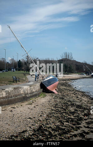 Portsmouth Harbour, Hampshire, UK. 28th March, 2016.  Yacht washed up against the sea wall after being swept from her anchorgae during Storm Katie on Easter Monday. Credit:  Rob Wilkinson/Alamy Live News Stock Photo