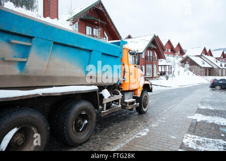 Truck with snow driving on the street of village in winter Stock Photo