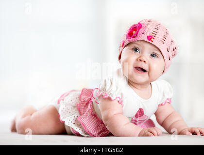 pretty smiling baby girl lying on stomach and looking up Stock Photo