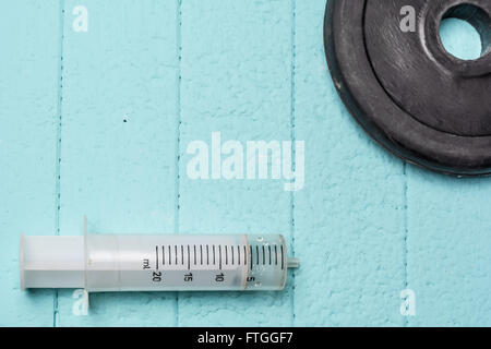 Injection and disc from dumbbell. Close-up. Blue background Stock Photo