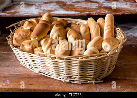 Wicker basket filled with fresh assorted white crusty rolls on display for sale in a bakery Stock Photo
