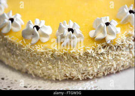 High Angle Close Up Culinary Still Life of Homemade Lemon Cake Decorated with Icing Flowers and Coconut Sprinkles - Stock Photo