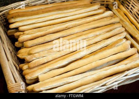 Freshly baked crunchy bread sticks in a wicker basket Stock Photo